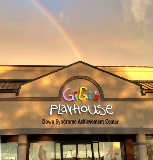 front view of GiGis Playhouse with rainbow in background