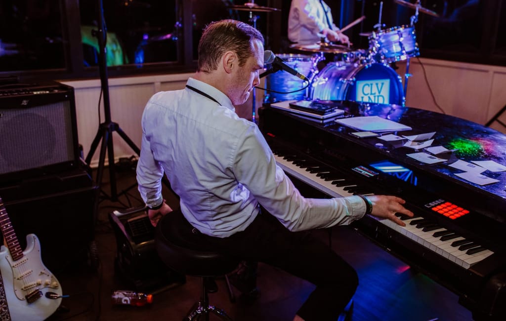 back view of greg playing the piano at event