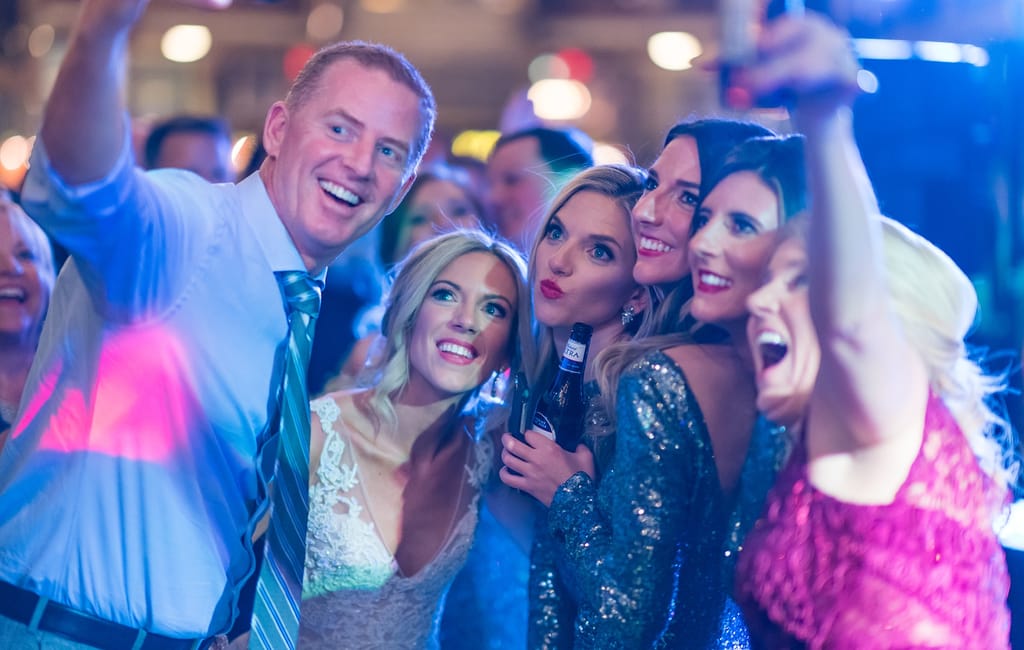 group of friends taking selfie at wedding