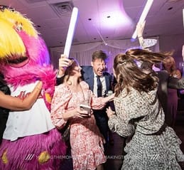 group of people dancing with cleveland guardians mascot