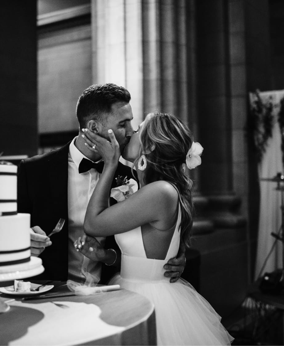 black and white portrait of bride and groom kissing